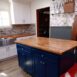 A finished kitchen island with painted blue cabinets and butcherblock top.