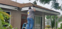 In Him Construction worker repair facia of a house.