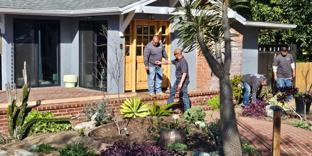 Raymond and worker with In Him Construction going over plans on house porch they built.
