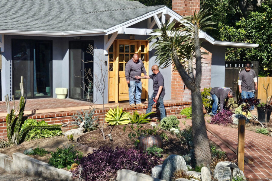Raymond and worker with In Him Construction going over plans on house porch they built.